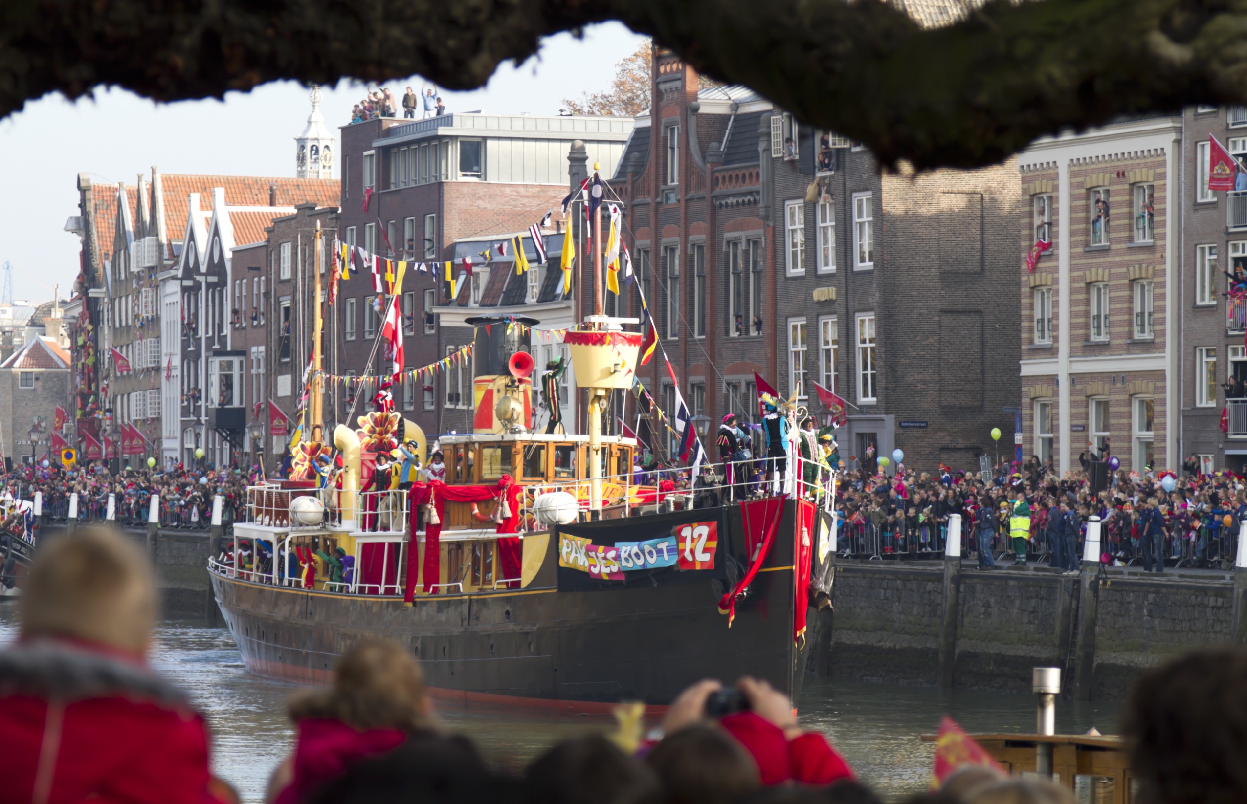 De magische reis van Sinterklaas: Pakjesboot 12 vaart door de Nederlandse wateren, vol met cadeaus en pepernoten, klaar om de harten van jong en oud te verwarmen.