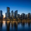 Skyline met moderne wolkenkrabbers aan het water bij schemering, als beeld bij de top 10 rijkste landen ter wereld.