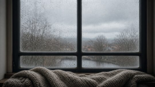 Beslagen raam met condensdruppels en een plaid op de vensterbank, als beeld bij de verwarming later aanzetten en vocht in huis.